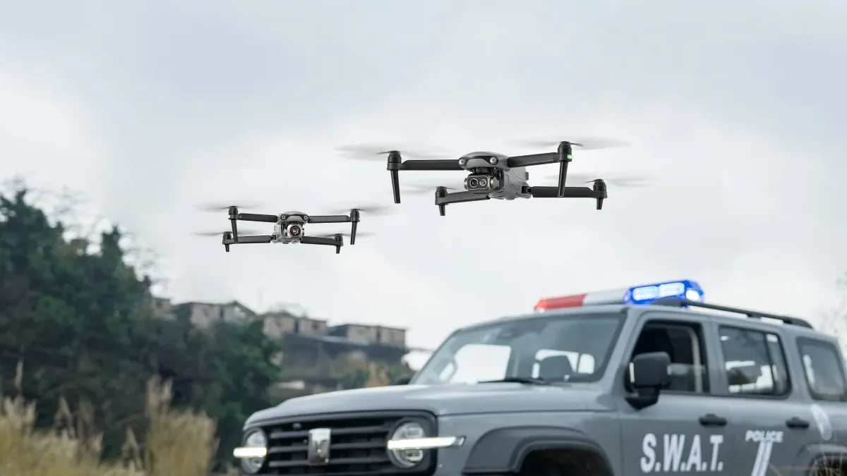 Dos Autel EVO Lite Enterprise en vuelo sobre un todoterreno de policía