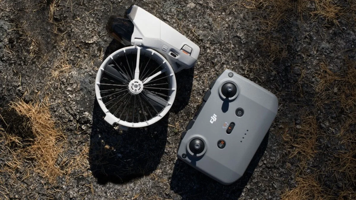 Un DJI Flip plegado y su mando RC-N3, vistos desde arriba sobre la hierba seca