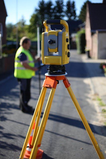 Topografo con estacion total junto al levantamiento con dron
