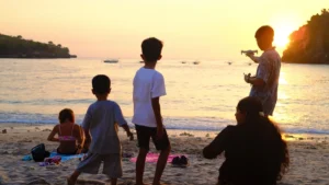 Una familia disfruta del atardecer en la playa mientras un joven hace volar un dron; la edad minima para volar un dron en Espana depende de la categoria.